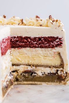 a close up of a slice of cake on a white plate with red and white frosting