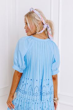 - Step into southern flair with this darling top! Its pleated texture and eyelet accent give it luxe style to elevate your look. Whether you are meeting up for tea on the patio or simply running your daily errands, this darling top will give you a touch of sweet southern charm. - Unlined pleated material with eyelet accents at the bottom - A round neckline - A buttoned front - Short sleeves with cuffs featuring smocked back details - A relaxed silhouette that ends in a scalloped hemline Spring Pleated Short Sleeve Blouse, Short Sleeve Pleated Blouse For Spring, Pleated Short Sleeve Blouse For Spring, Spring Pleated Tops, Feminine Pintuck Top For Summer, Chic Blue Tops With Pleated Sleeves, Feminine Summer Top With Pintucks, Feminine Pintucks Top For Summer, Feminine Summer Tops With Pintucks