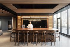 a man standing in front of a bar with stools