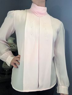 This long sleeve light pink blouse features a beautiful embroidered design and wide pleats on the front. It buttons down the back. It is estimated to have been made in the 1980s and is 100% polyester. This blouse would be wonderful for casual or professional looks for spring and summer. Brand: Kelley Scott Size/Measurements: This blouse's tag reads size 6. When laying flat, the blouse measures 19.5 inches across the bust and 25.5 inches in length. Friendly reminder: due to age and wear, vintage clothing can be slightly discolored, have minor stains, missing buttons, loose threads etc. PLEASE NOTE: Returns are not accepted for clothing items for health safety reasons. If you have questions about measurement, size, or fit, please contact me. Buying vintage items is not only a great way to re Elegant Long Sleeve Pink Blouse, Elegant Pink Long Sleeve Blouse, Pink Long Sleeve Blouse For Daywear, Pink Long Sleeve Formal Top, Formal Long Sleeve Pink Tops, Vintage Pink Blouse For Formal Occasions, Classic Pink Long Sleeve Blouse, Classic Long Sleeve Pink Blouse, Pink Long Sleeve Formal Blouse