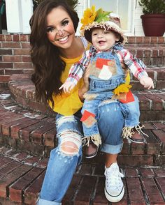 a woman sitting on the steps with a child in her lap wearing sunflowers