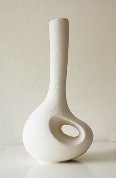 a white vase sitting on top of a table