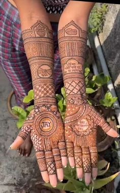 a woman's hands with henna tattoos on them