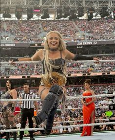 a woman standing on top of a wrestling ring