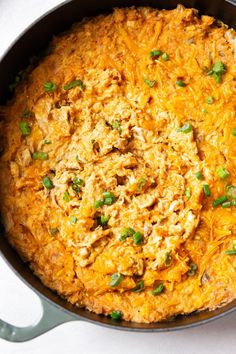 a casserole dish with cheese and green onions on the side, ready to be eaten