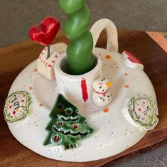 a ceramic christmas decoration with a tree and snowmen