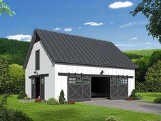 a white barn with a black roof and two garage doors on the side of it