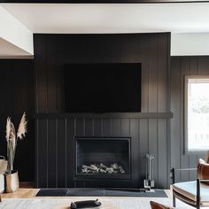 a living room with dark wood paneling and a flat screen tv above the fireplace