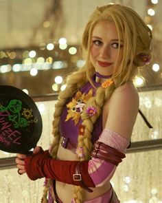 a woman with long blonde hair and braids holding a frisbee in her hand