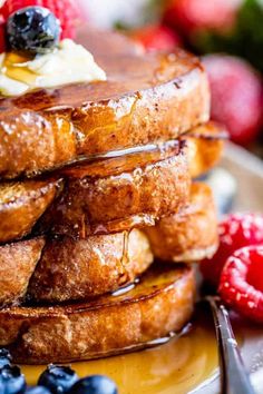 a stack of french toast topped with butter and berries