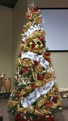 a christmas tree decorated with gold and red ribbons