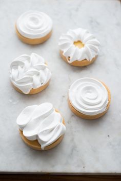 four cookies with white icing on a marble surface