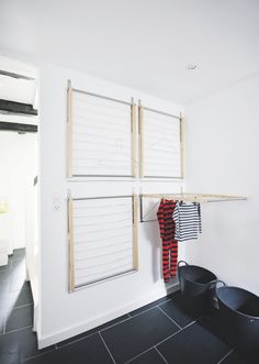 a bathroom with black tile flooring and white walls, along with an open window