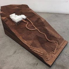 a model of a building on top of a wooden table that is shaped like a mountain