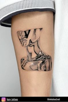 a black and white photo of a woman's leg with a tattoo on it