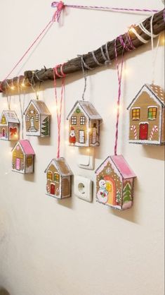 christmas decorations are hanging on the wall in front of a white wall with string lights