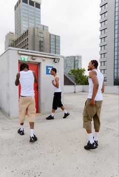 three men standing in front of a red door