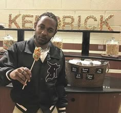 a man in a black jacket holding a candy bar