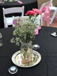 a vase filled with flowers sitting on top of a table next to silverware and utensils