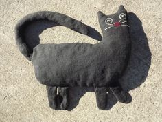 a black cat stuffed animal laying on the ground