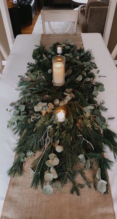 the table is set with candles and greenery