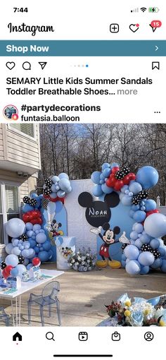 an image of a mickey mouse birthday party with balloons and streamers on the wall