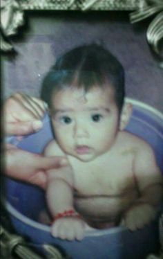 a baby is sitting in a blue bowl