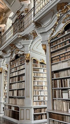 an ornate library with many bookshelves filled with lots of books and gold trimmings