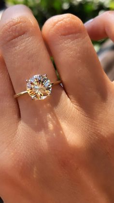 a woman's hand with a ring on it and a diamond in the middle