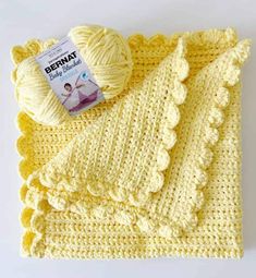 a crocheted blanket and ball of yarn