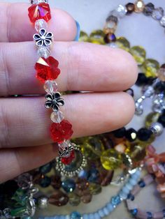 Swarovski red crystal flowers on a dainty spring bracelet. Red Flower-shaped Beaded Bracelets For Jewelry Making, Adjustable Red Jewelry With Flower Charm, Red Flower-shaped Handmade Bracelets, Handmade Red Flower Bracelets, Handmade Red Flower Bracelet, Red Beaded Dainty Bracelets, Silver Flower Crystal Bracelet Gift, Silver Flower Crystal Bracelet As Gift, Red Czech Glass Bracelet