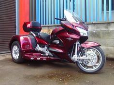 a red motorcycle parked in front of a building