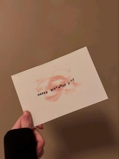 a person holding up a card with the words happy birthday written in red on it