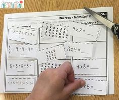 someone is cutting out the missing numbers for their math worksheet