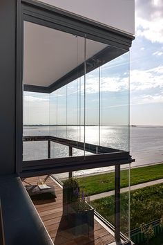 a balcony overlooking the ocean with glass walls