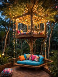 a tree house with lights on the roof and blue couch in the foreground, surrounded by palm trees