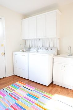 a white washer and dryer sitting next to each other on top of a wooden floor