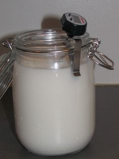 a glass jar filled with white liquid sitting on top of a table