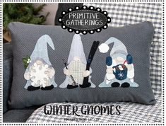 three gnomes sitting on top of a pillow in front of a chair with the words primitive