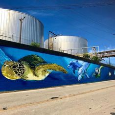 a mural on the side of a building depicts a turtle and other marine animals in blue water