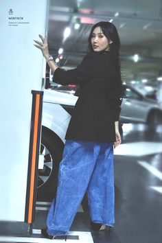 a woman standing next to a white car