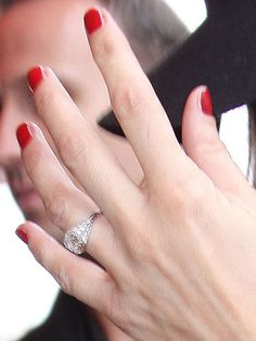 a close up of a person holding a cell phone to their ear and wearing a ring