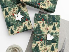 wrapping paper with christmas trees on it next to scissors and twine spools