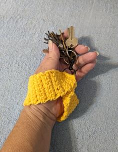 a person holding keys in their hand on the floor with carpeted area behind them