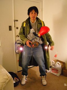 a man standing in a room holding a red object with two lights on his hands