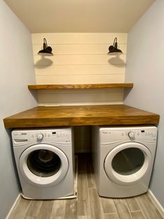 a washer and dryer in a room with two lights on the wall above them