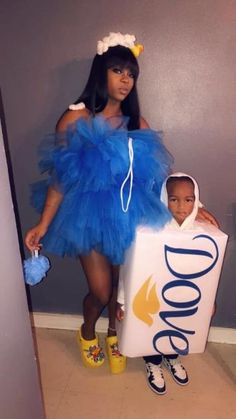 a woman standing next to a child in a blue dress and holding a sign that says dole