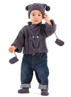 a little boy wearing a knitted bear hat and holding a cell phone to his ear