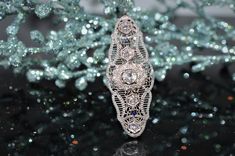 A Ladies 14K White Gold Antique Filigree Diamond Pin/Pendant With An Approx .80 Carat Round Center Diamond (JK/I1), 4 - Approx .20 Carat Round Diamonds (HI/I1), And 20 Small Round Diamonds. The Total Weight Of All Diamonds Is Approximately 1.95 Carats. The Pin/Pend Comes With An Antique 16 Inch Long Link Chain Ornate Diamond White Filigree Jewelry, Ornate Filigree Diamond White Jewelry, Ornate Diamond White Jewelry With Filigree, Exquisite Filigree Pendant Jewelry, Art Deco Filigree Pendant Jewelry, Luxury Filigree Evening Jewelry, Luxury Evening Jewelry With Filigree, Victorian Platinum Filigree Jewelry, Gem Water