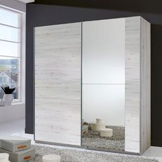 a white and black room with a large mirror on the wall